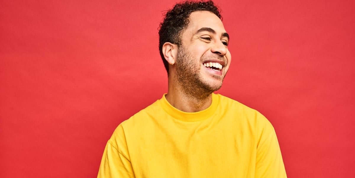 smiling man in front of bright red backdrop