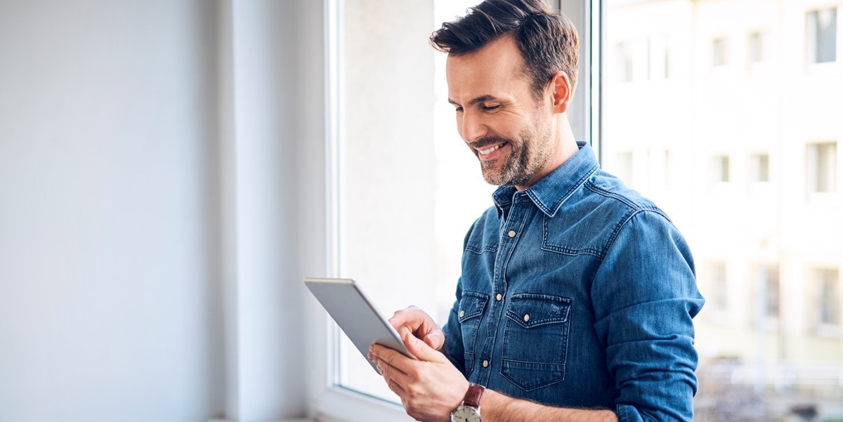 man standing alone looking at cellphone in hand