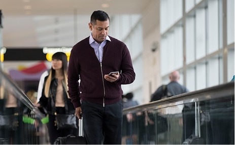 Man walking through airport on mobile