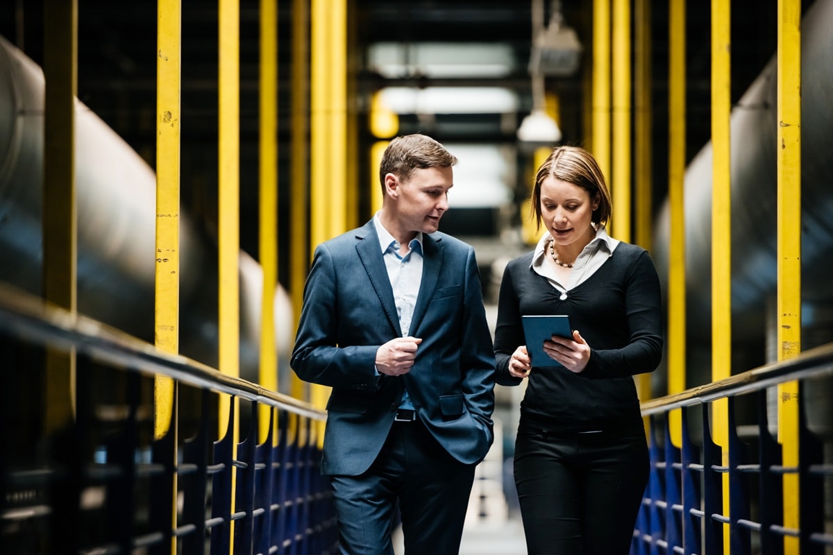 Two people walking through office