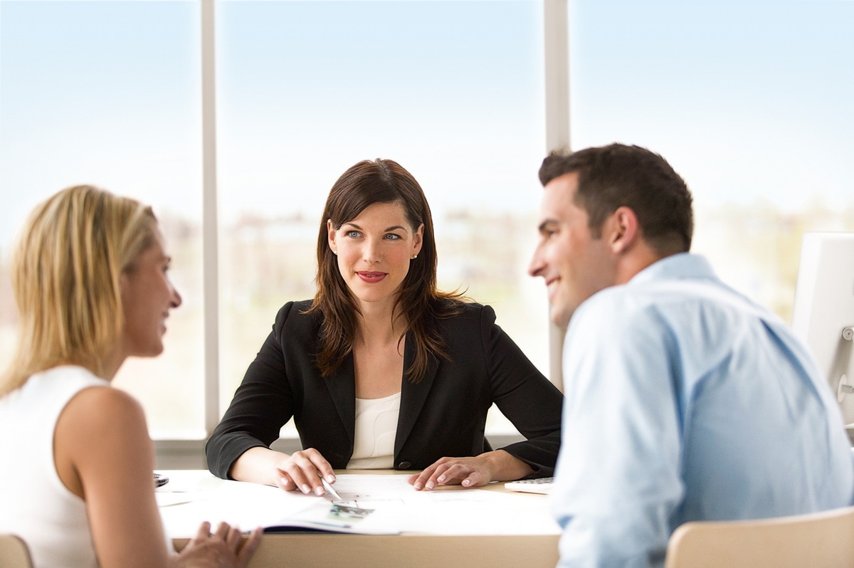 Three people sitting around a desk